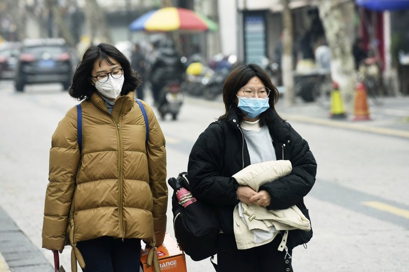 Mujeres con cubrebocas caminan por una calle en Hangzhou, en el este de China, martes 21 de enero de 2020. Se agotaron los cubrebocas, y se impuso el control de la temperatura corporal en aeropuertos y estaciones ferroviarias el martes en China, en el intento de frenar el brote de un nuevo coronavirus que se ha extendido a otros cuatro países y territorios.(Chinatopix via AP)