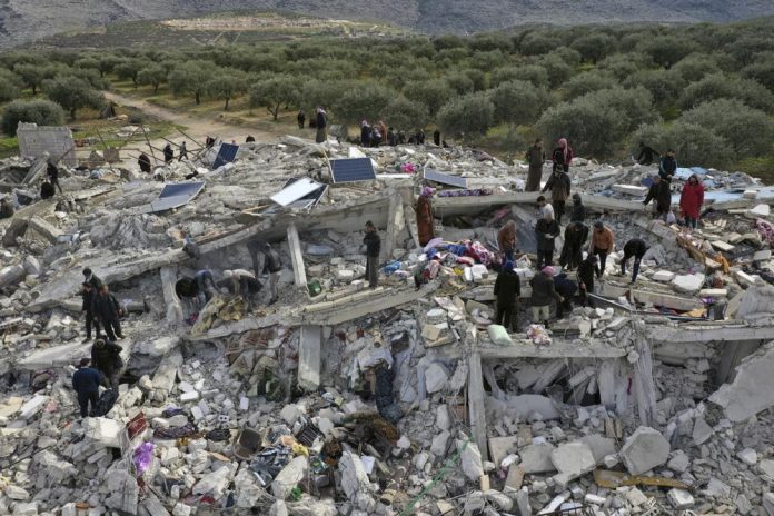 Socorristas y residentes buscan entre los escombros de los edificios derrumbados por un temblor en la ciudad de Harem, cerca de la frontera turca, provincia de Idlib, Siria, el lunes 6 de febrero de 2023. (Foto AP/Ghaith Alsayed)