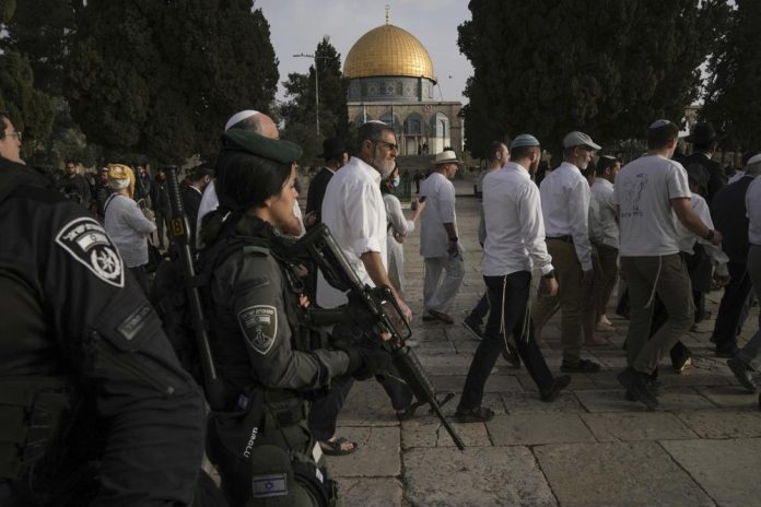 Policías israelíes escoltan a visitantes judíos en el feriado de Pascua en el complejo de la mezquita de Al Aqsa, conocido como Explanada de las Mezquitas, en la zona antigua de Jerusalén, durante el mes sagrado islámico del Ramadán, el domingo 9 de abril de 2023. (AP Foto/Mahmoud Illean)