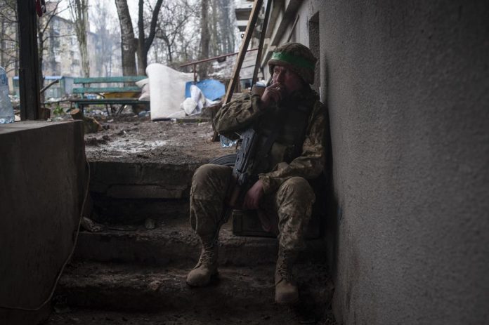 Un soldado ucraniano fuma mientras descansa en la maltrecha ciudad de Bájmut, en la región de Donetsk, Ucrania, el miércoles 12 de abril de 2023. (Iryna Rubakova via AP)